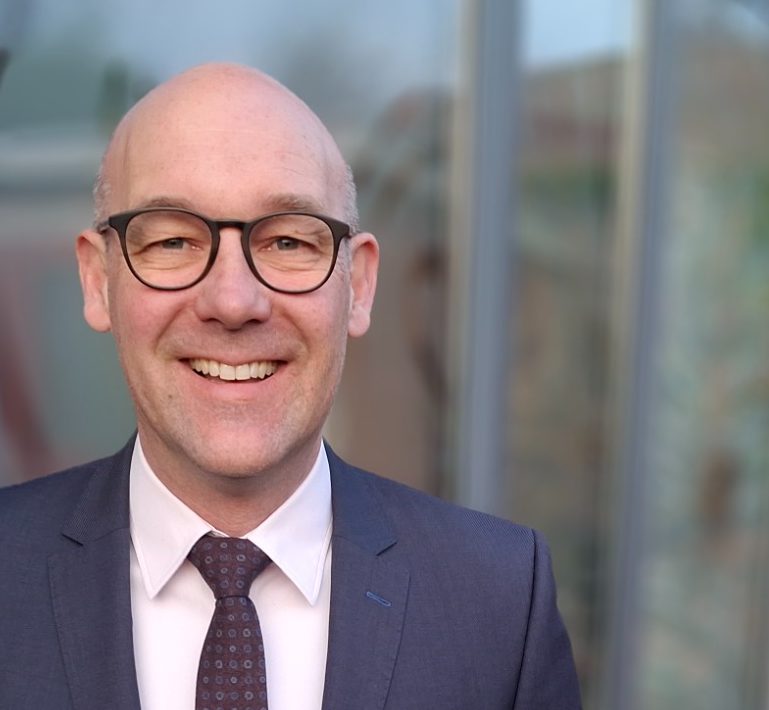 Portrait von Kristjan Diehl vor einem Bürogebäude.
